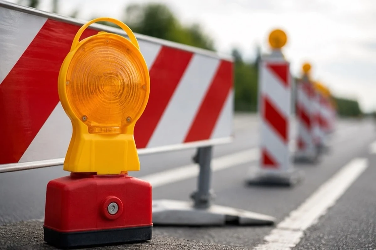 Halbseitig gesperrte Bundesstraße unter einer Autobahnbrücke mit Leitbaken, Baustellenampel und Fahrzeugen im Harz