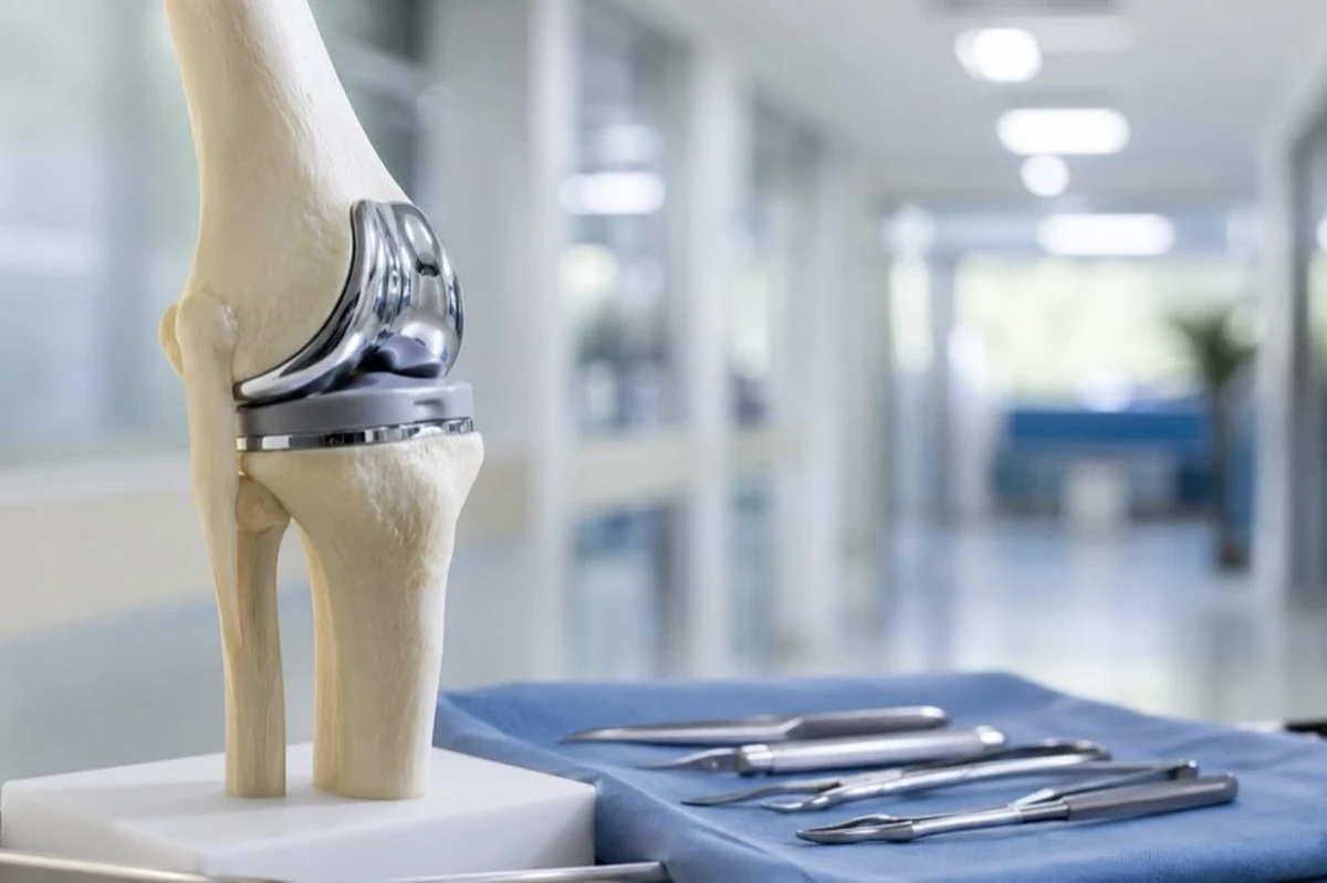 Anatomisches Kniegelenk-Modell und medizinische Instrumente in einem neutralen Krankenhausflur