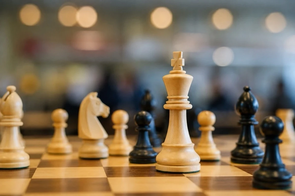 Schachbrett mit schwarzen und weißen Figuren vor Spieltischen zum Thema Schach in Derenburg im Harz
