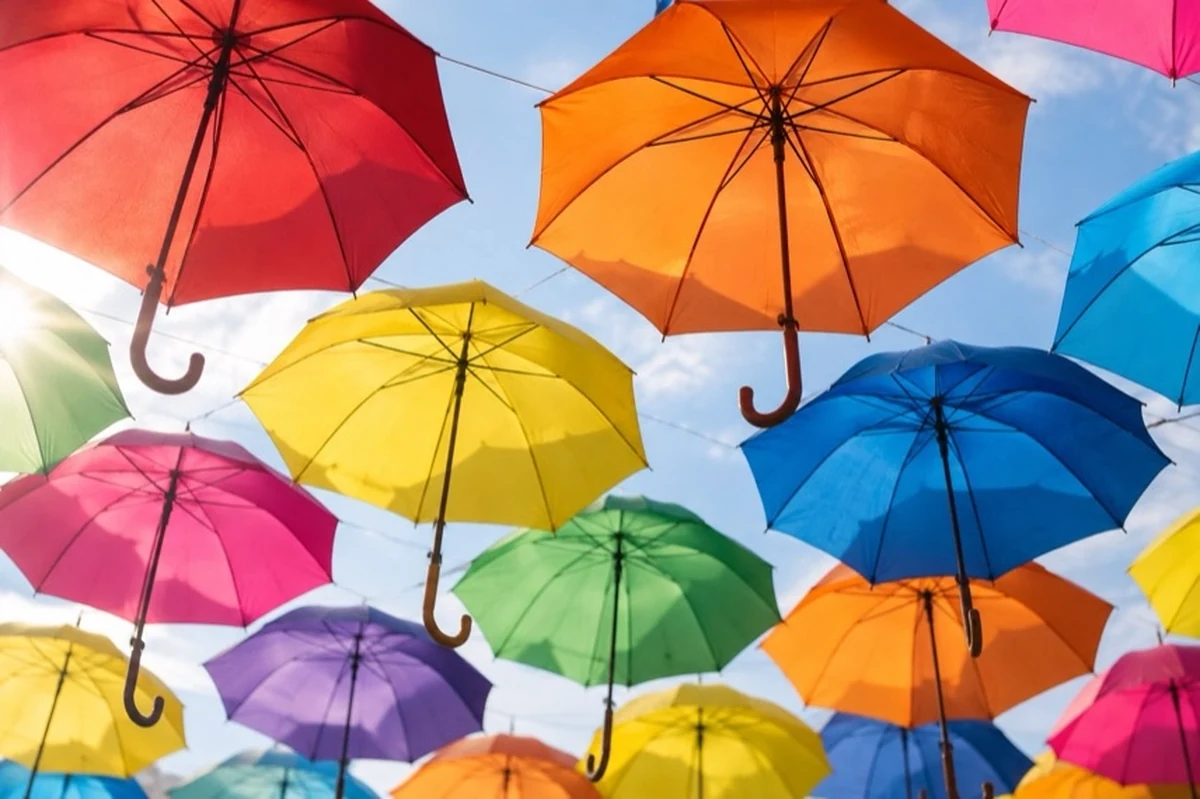 Bunte Regenschirme hängen über einem neutralen Fußgängerbereich als Motiv für die Regenschirmgasse in Goslar.