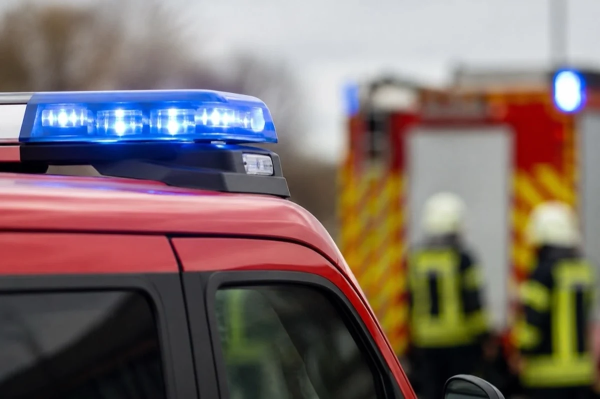 Generisches Feuerwehrfahrzeug vor anonymer Industriehalle mit Schläuchen im Goslarer Industriegebiet
