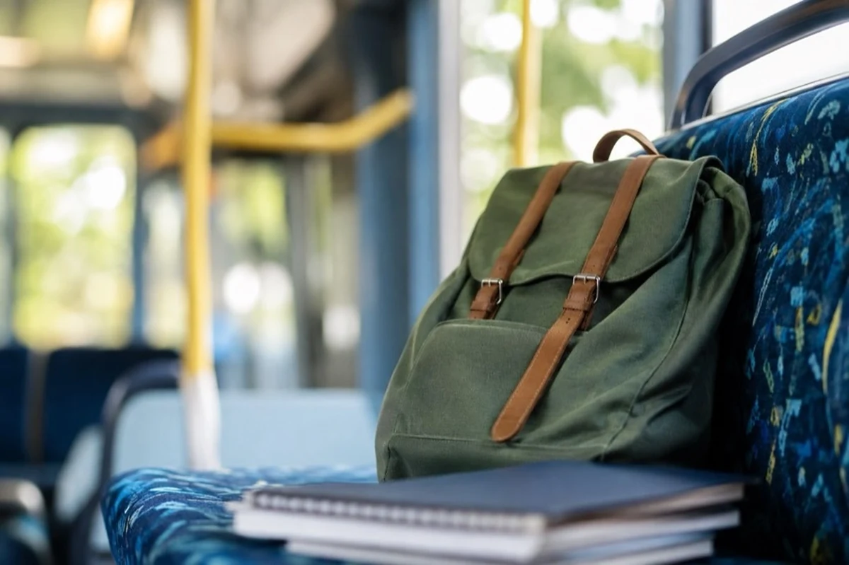 Kind mit Begleitperson an einer Bushaltestelle neben einem Linienbus für den Schulweg im Kreis Goslar