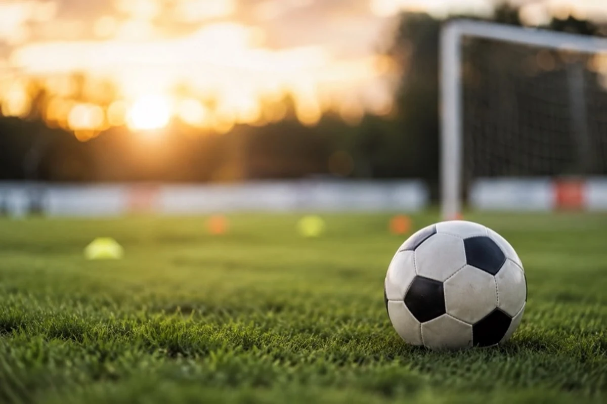 Fußball und Trainingshütchen auf neutralem Platz mit anonymen Spielern zum Fußball in Bad Harzburg