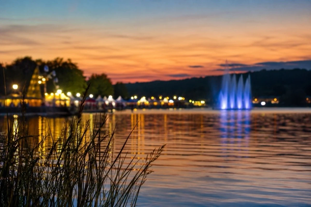 Ruhiger See mit Wasserfontäne und dekorativer Festbeleuchtung als Symbol für das Vienenburger Seefest im Harz