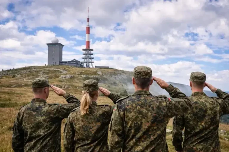 Vier Bundeswehr-Soldaten salutieren auf dem Brockenplateau im Harz vor Sendeanlagen, aufgenommen bei Tageslicht ohne erkennbare Identitäten