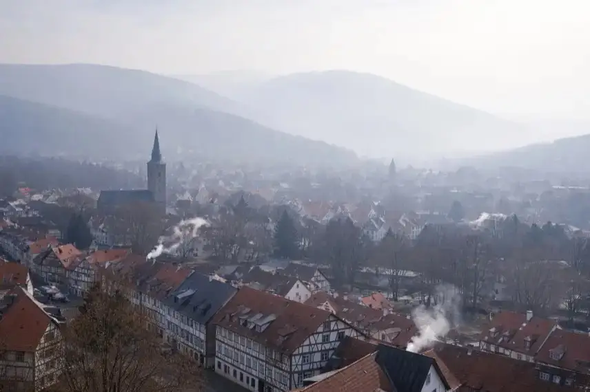 Blick über Wernigerode mit winterlichem Dunst und eingeschränkter Sicht, Dächer und Straßen unter feinstaubbelasteter Luft